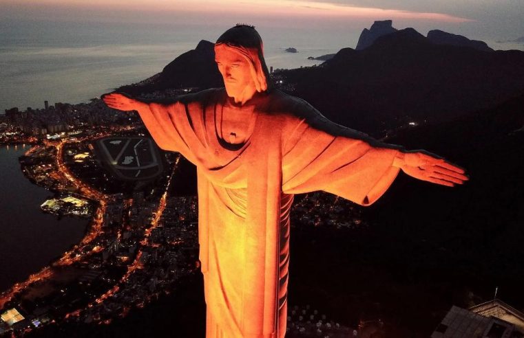 Santuário Cristo Redentor homenageia Comlurb pelos 49 anos e ilumina monumento em laranja pelo Dia do Gari