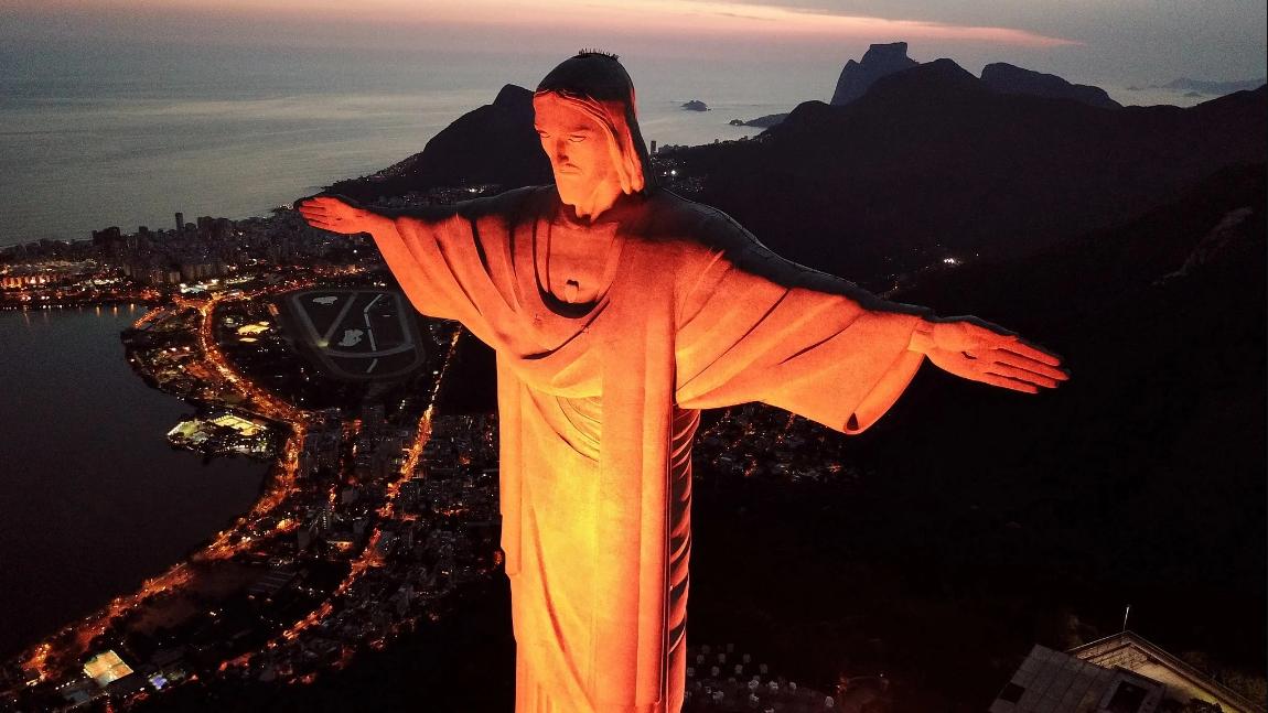 Santuário Cristo Redentor homenageia Comlurb pelos 49 anos e ilumina monumento em laranja pelo Dia do Gari