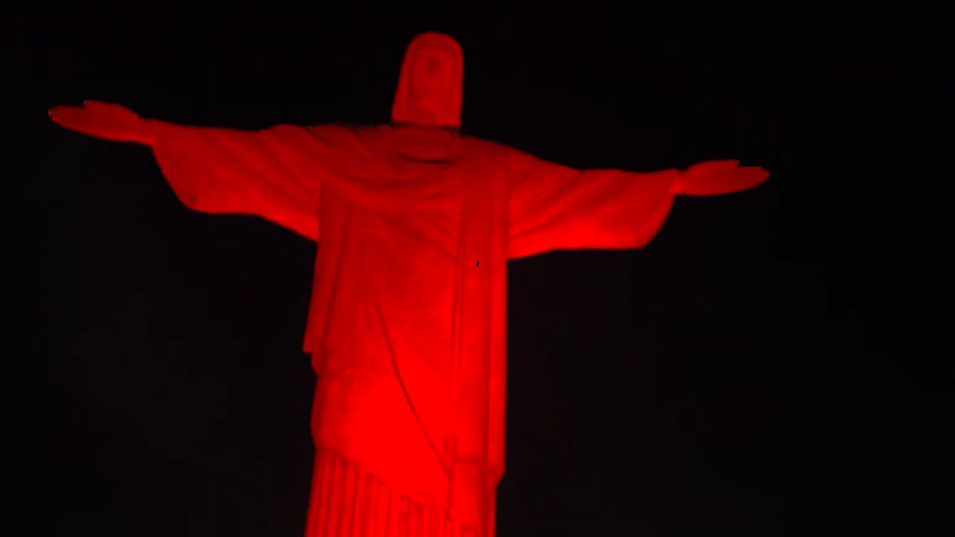 Cristo Redentor recebe iluminação vermelha para marcar Dia Nacional de Luta da População em Situação de Rua